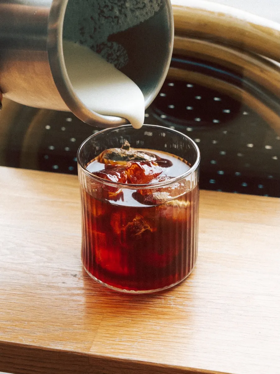 Milk poured over an iced autumn drink