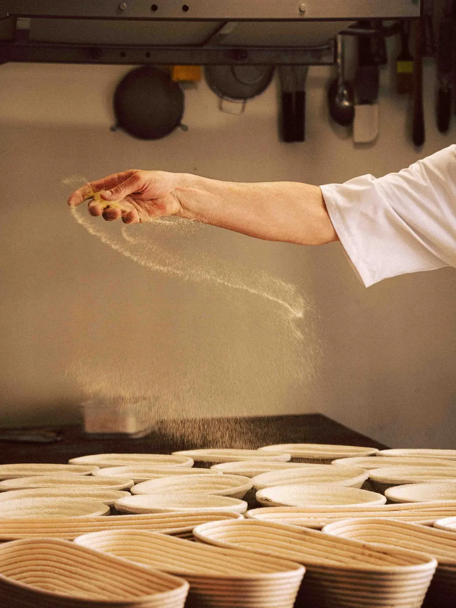 Flour thrown over rows of proving baskets