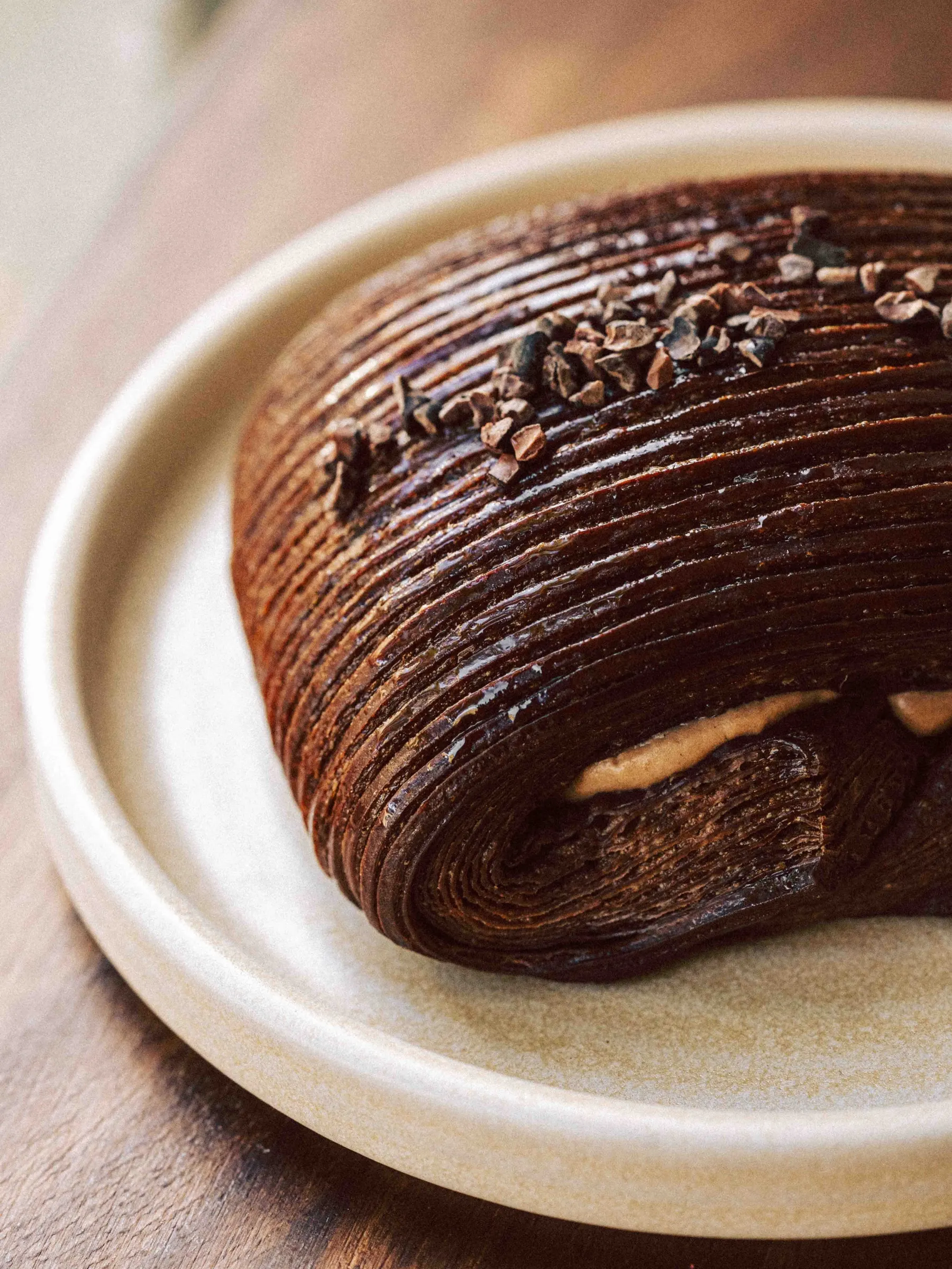 A dark chocolate pastry on a stoneware plate